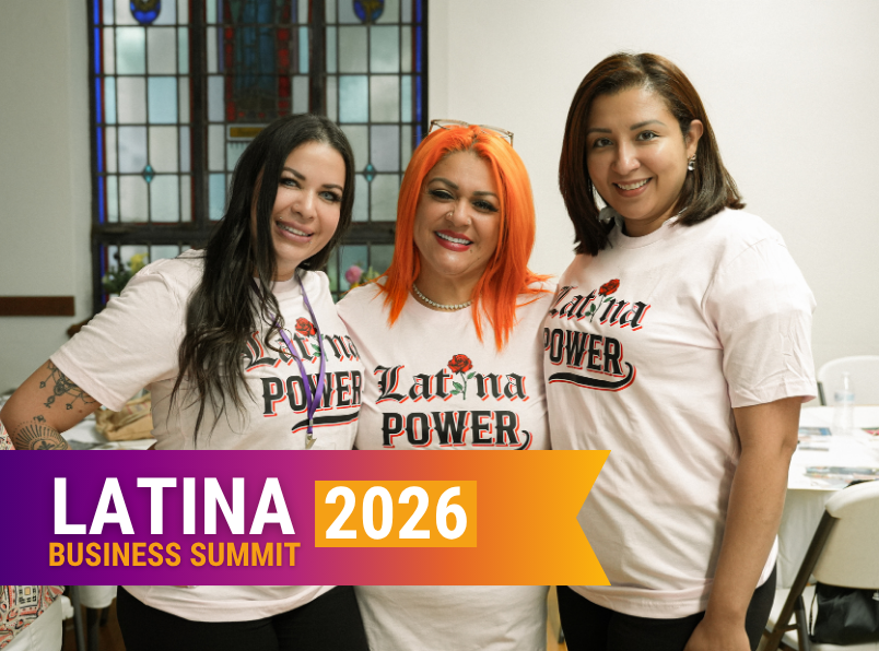 Three women wearing light pink 'Latina Power' shirts pose together at a banner for the 2026 Latina Business Summit.